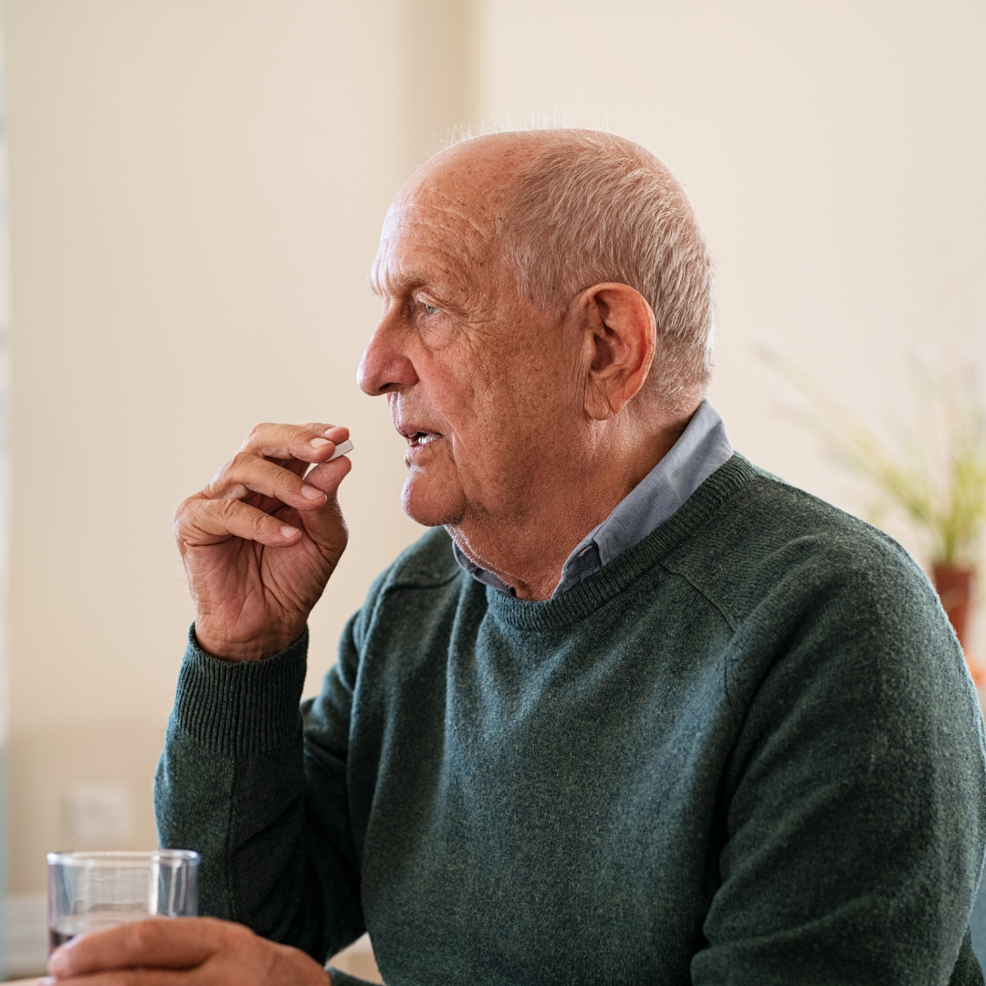 Elderly Man Swallowing A Pill